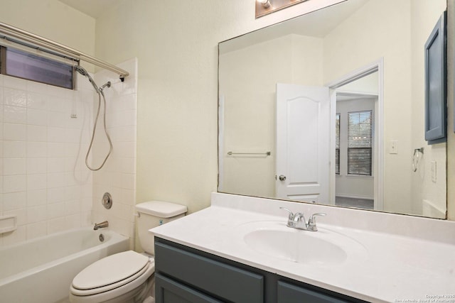 full bathroom featuring tiled shower / bath combo, vanity, and toilet