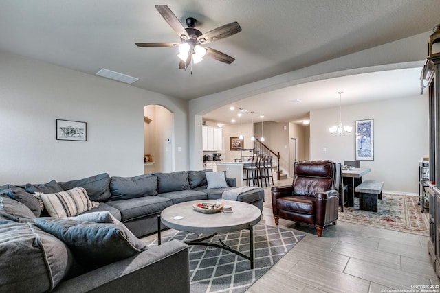 living room with ceiling fan with notable chandelier