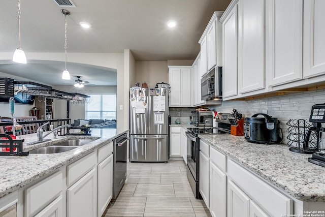 kitchen with decorative light fixtures, white cabinetry, stainless steel appliances, sink, and ceiling fan