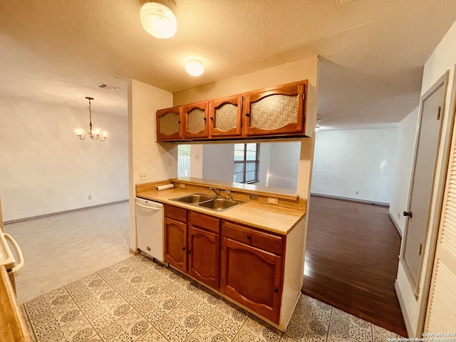 kitchen with hanging light fixtures, dishwasher, sink, and a chandelier