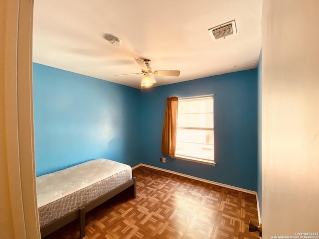 bedroom featuring ceiling fan and dark parquet floors