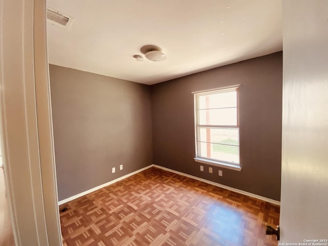 spare room featuring parquet flooring