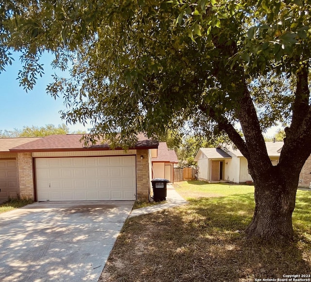 single story home featuring a garage and a front yard