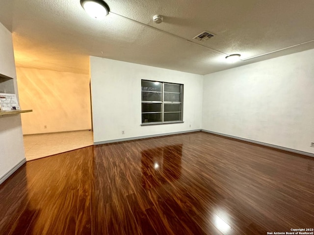 empty room with a textured ceiling and hardwood / wood-style floors