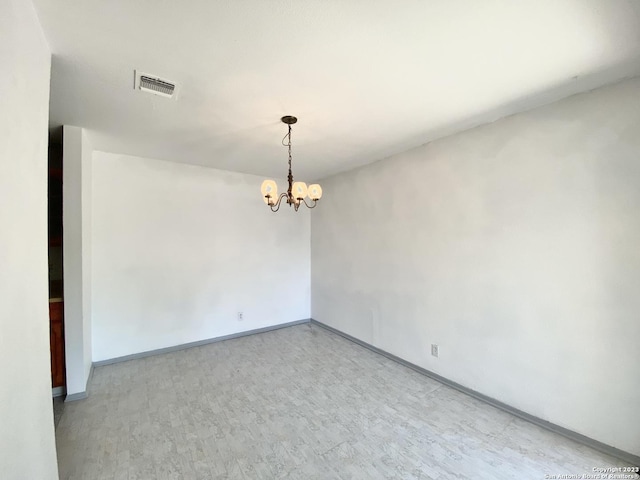 empty room featuring a chandelier