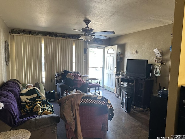 living room with ceiling fan and a textured ceiling