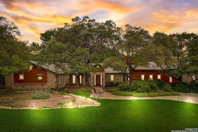 view of front of property with a patio area and a yard