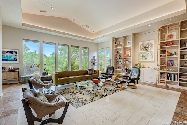 tiled living room with vaulted ceiling and a tray ceiling