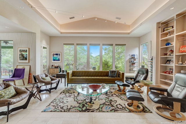 tiled living room with vaulted ceiling, a wealth of natural light, and a raised ceiling