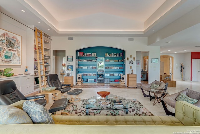 living room with a tray ceiling and built in features