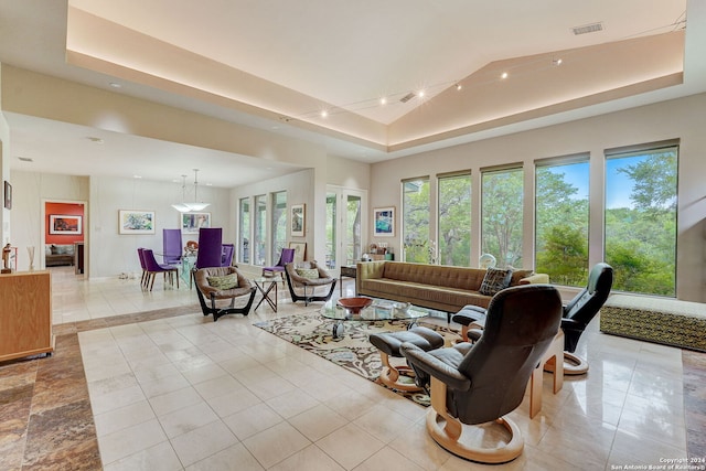 tiled living room featuring a raised ceiling