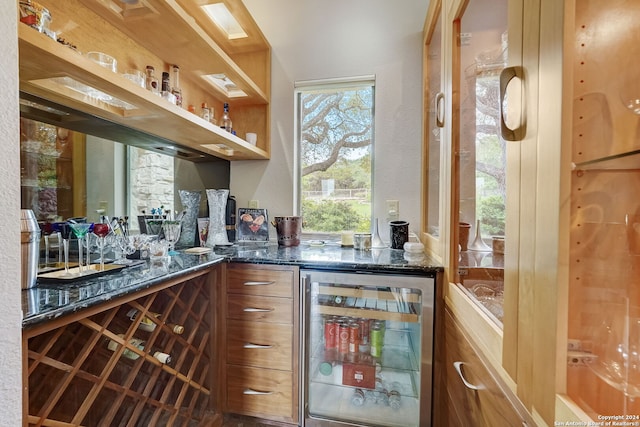 bar featuring wine cooler and dark stone counters