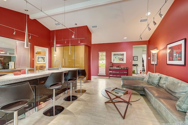 living room featuring beam ceiling, sink, and high vaulted ceiling