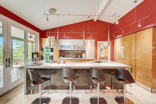 kitchen with beam ceiling, sink, high vaulted ceiling, stainless steel double oven, and french doors