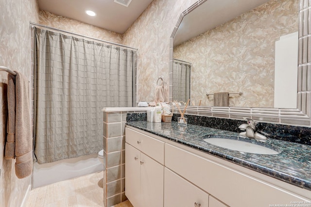 full bathroom with toilet, vanity, and shower / bath combo