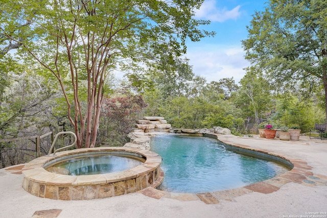 view of pool featuring a patio area and an in ground hot tub