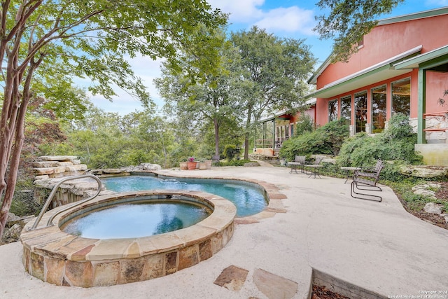 view of pool with a patio area and an in ground hot tub