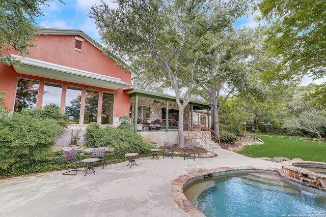 view of pool with an in ground hot tub, a lawn, ceiling fan, and a patio