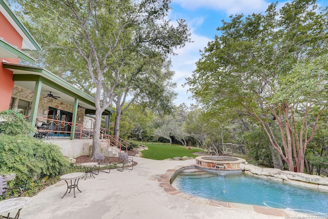 view of pool featuring ceiling fan, a patio area, a yard, and an in ground hot tub