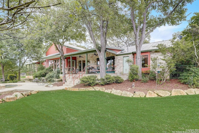 view of front of house with a front yard, ceiling fan, and a patio