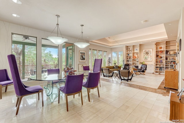 tiled dining space featuring a raised ceiling