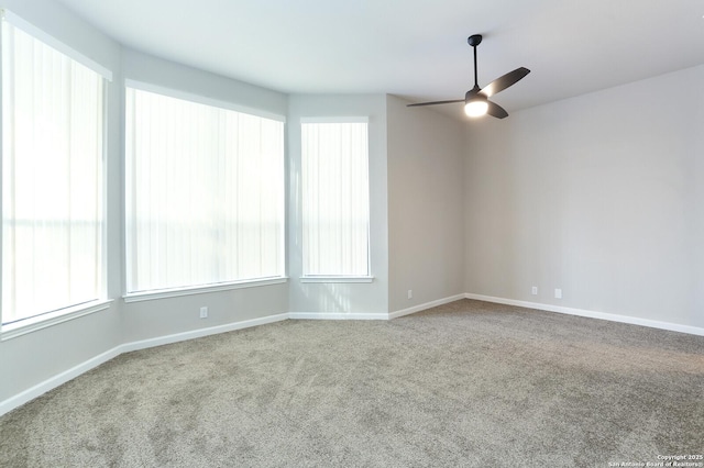 carpeted spare room featuring ceiling fan