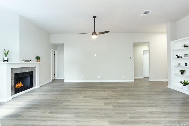 unfurnished living room featuring light wood-type flooring, ceiling fan, and built in features