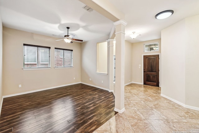 foyer with ceiling fan, light wood-type flooring, and ornate columns