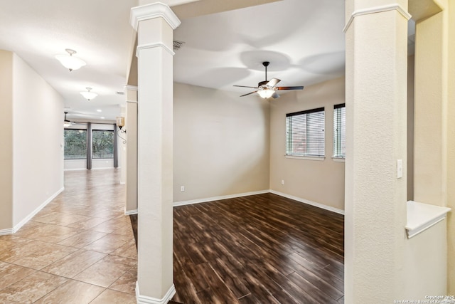 unfurnished room featuring ornate columns, a wealth of natural light, and ceiling fan