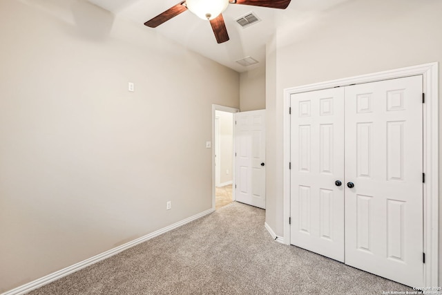 unfurnished bedroom featuring ceiling fan, a closet, and light carpet