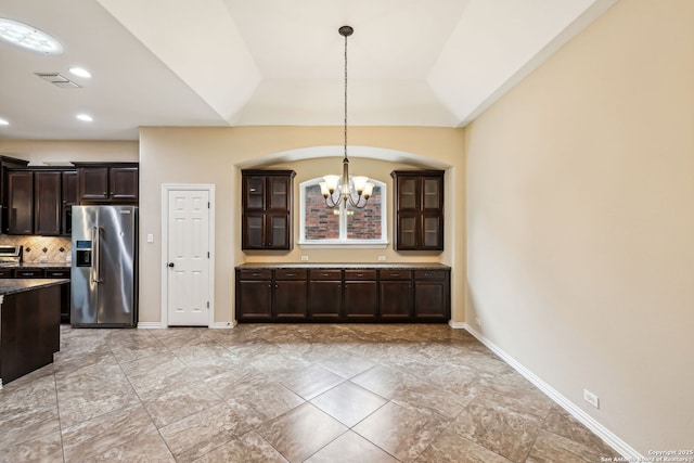 kitchen featuring lofted ceiling, decorative light fixtures, a notable chandelier, stainless steel fridge with ice dispenser, and dark brown cabinets