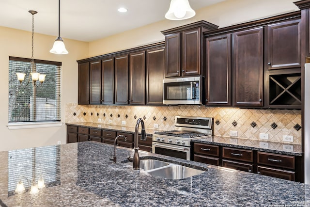 kitchen featuring appliances with stainless steel finishes, decorative backsplash, hanging light fixtures, dark brown cabinetry, and sink