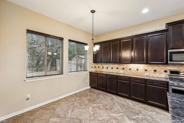 kitchen featuring decorative light fixtures, stainless steel appliances, dark stone countertops, backsplash, and dark brown cabinets