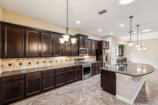 kitchen featuring sink, pendant lighting, backsplash, and stainless steel appliances