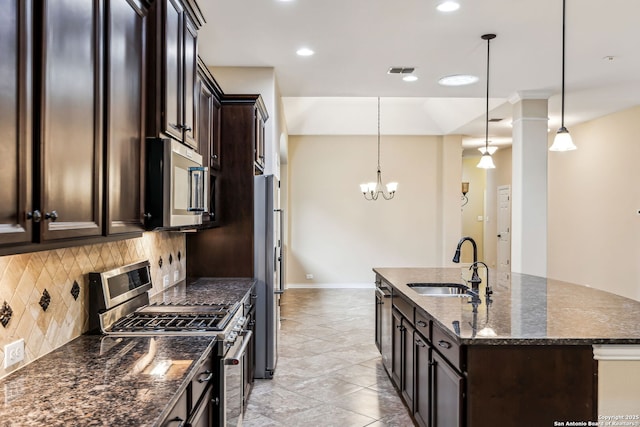 kitchen with appliances with stainless steel finishes, tasteful backsplash, dark brown cabinets, pendant lighting, and sink