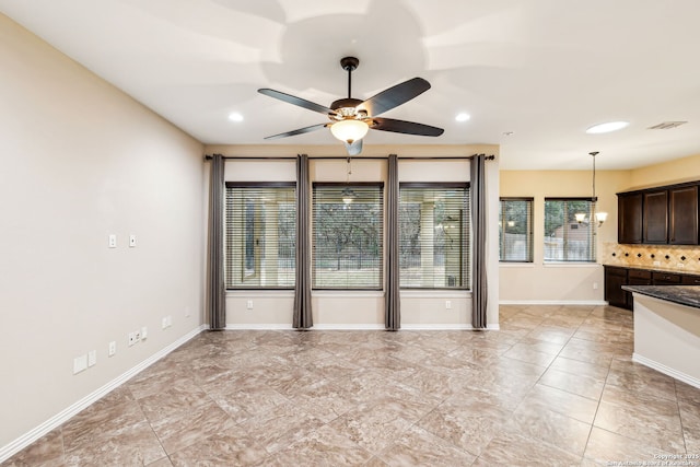 interior space with ceiling fan with notable chandelier