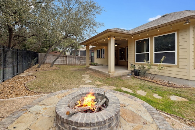 view of yard with ceiling fan, a patio area, and an outdoor fire pit