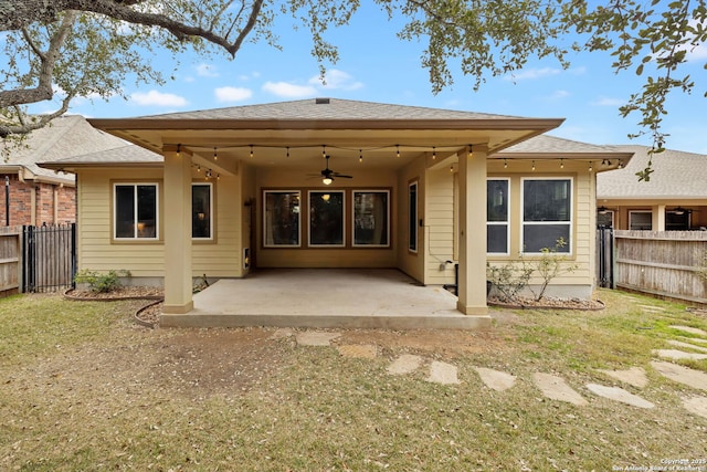 rear view of property featuring ceiling fan, a patio area, and a yard