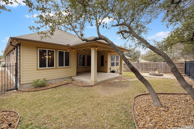 rear view of house featuring a lawn, an outdoor fire pit, and a patio