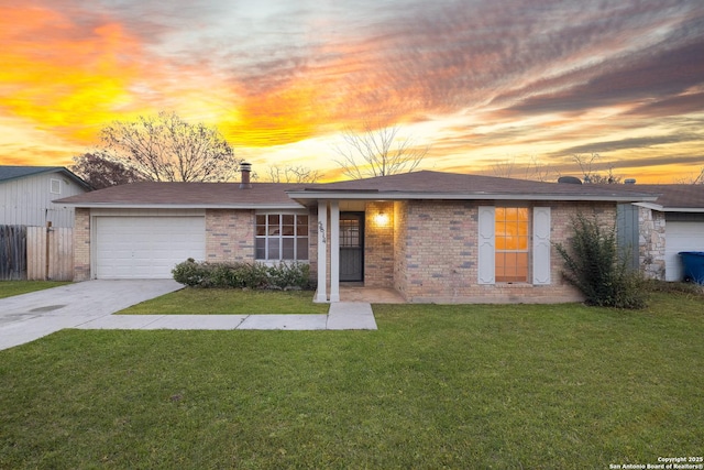 ranch-style home featuring a lawn and a garage