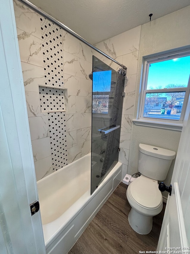 bathroom featuring toilet, wood-type flooring, a textured ceiling, and shower / bathtub combination with curtain