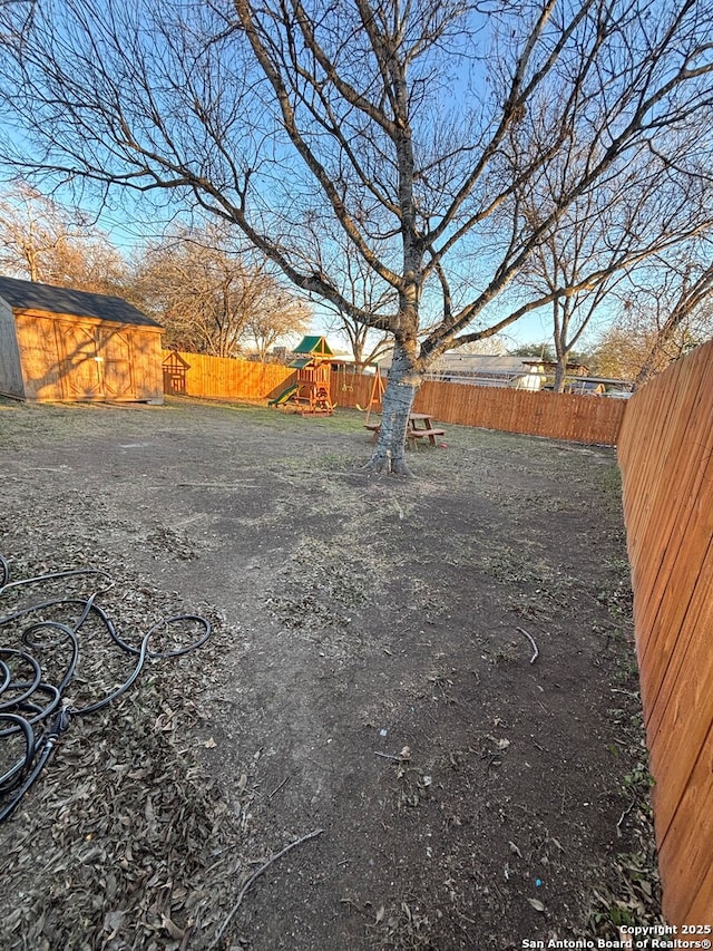 view of yard featuring a playground and a storage shed