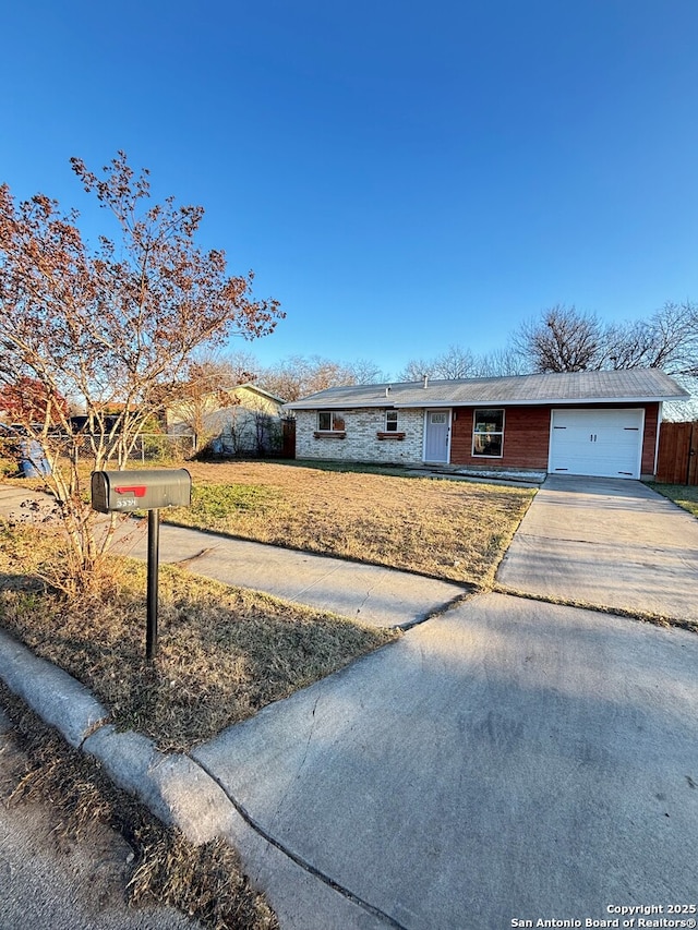 single story home featuring a front lawn and a garage