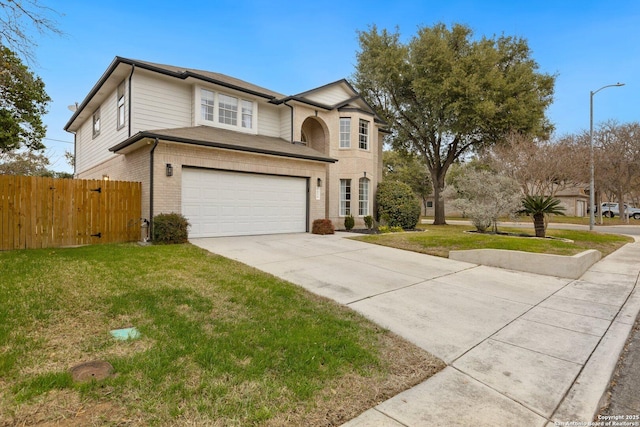 traditional-style home with driveway, a front yard, fence, and brick siding