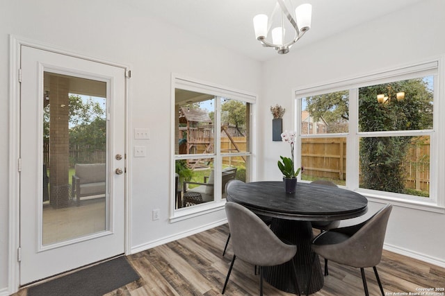 dining area with a notable chandelier, baseboards, and wood finished floors