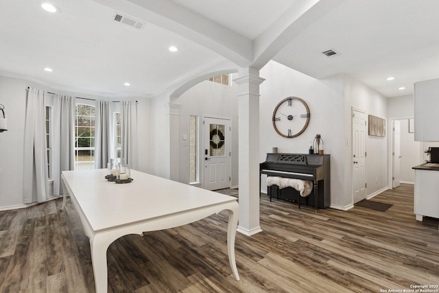 kitchen featuring arched walkways, dark wood-style floors, and visible vents