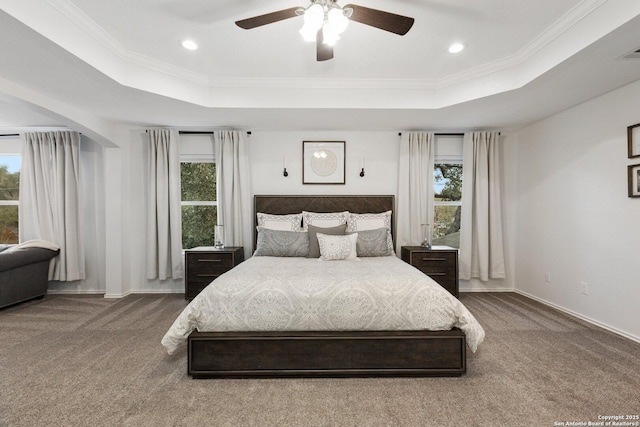 bedroom with carpet, a tray ceiling, and ornamental molding