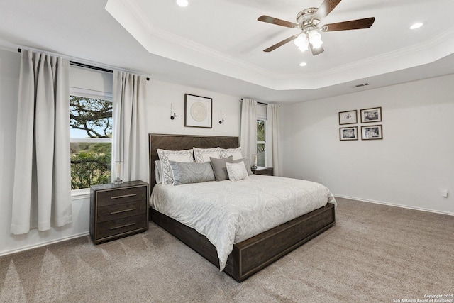 bedroom with carpet floors, ornamental molding, a raised ceiling, and visible vents