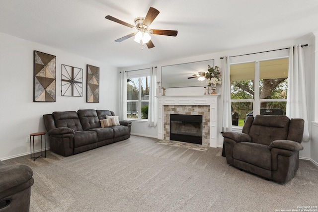 carpeted living room with a fireplace with flush hearth, baseboards, and a ceiling fan