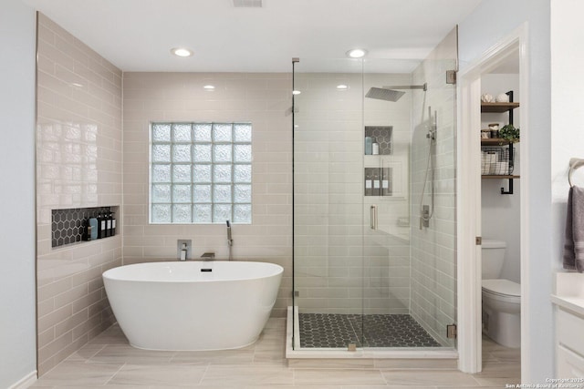 full bathroom featuring a freestanding tub, visible vents, a shower stall, and toilet